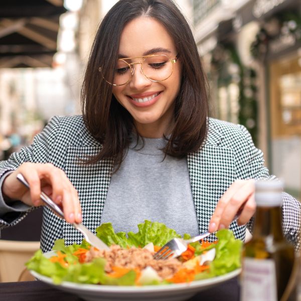 woman eating salad at restaurant